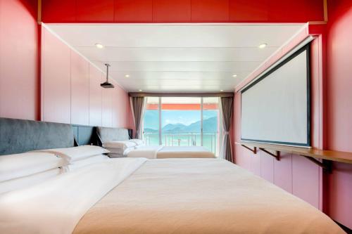 a bedroom with two beds and a large window at Shenzhen Maancoco Seaview Villa Jiaochangwei Coastline in Dapeng