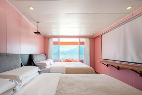 a room with three beds and a projection screen at Shenzhen Maancoco Seaview Villa Jiaochangwei Coastline in Dapeng