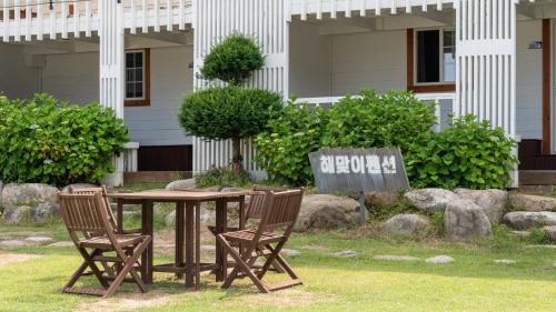 a wooden table with two chairs and a sign at goseong haemaji pension in Goseong