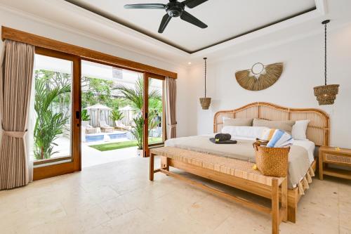 a bedroom with a bed and a sliding glass door at Villa Mawali in Legian
