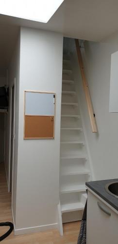 - un escalier dans une chambre dotée d'un mur blanc dans l'établissement Maison CALAIS centre ville C, à Calais