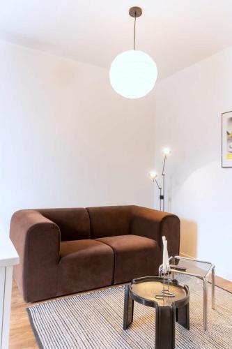 a living room with a brown couch and a table at Appart lumineux et chaleureux in Montréal