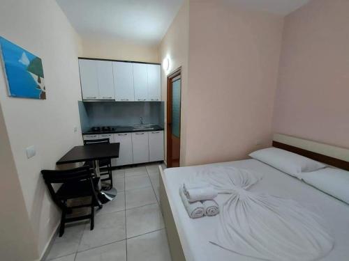 a bedroom with a bed and a table and a kitchen at TRiAD in Vlorë
