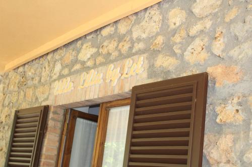 a building with a sign on the side of it at Villa Lilia by Let in Siena