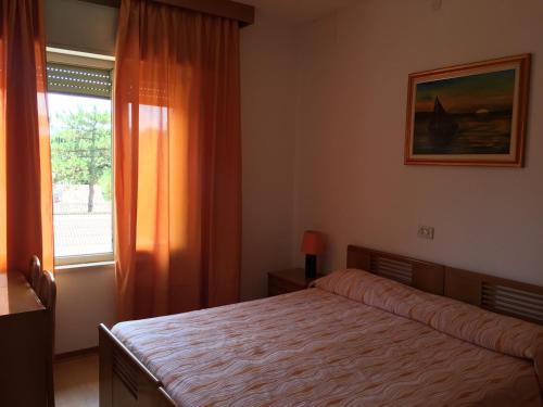 a bedroom with a bed and a window at Pensione Giardino in Lignano Sabbiadoro