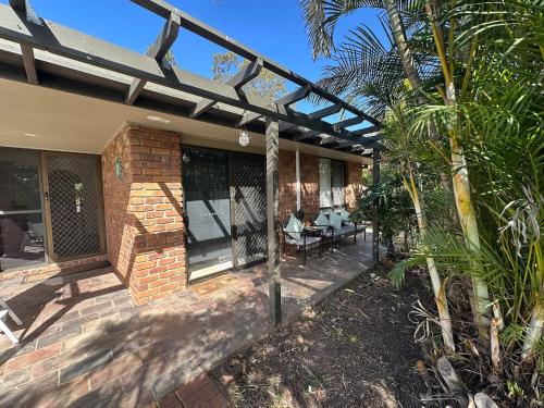a brick house with a pergola and a patio at Comfortable 1 Bedroom Granny Flat with Parking Alexandra Hills in Ormiston