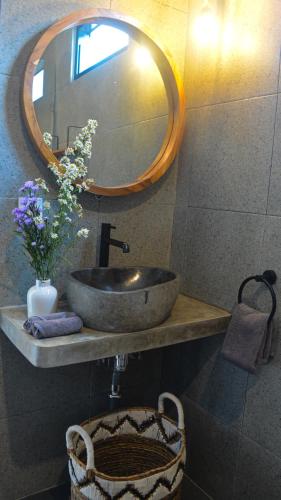 a bathroom with a sink and a mirror and a basket at Pandan Villas, Canggu in Dalung