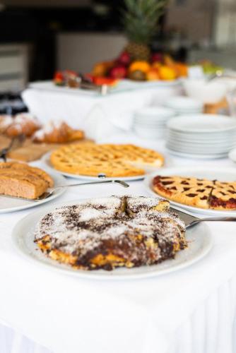 a table with white plates of food on it at Hotel De Nac in Nago-Torbole