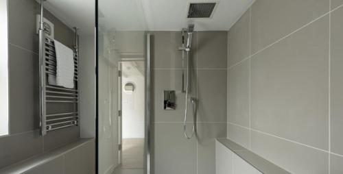 Un baño con ducha con puerta de cristal. en VITAMYN SEA, 4 bed house, Sleeps 8, Sea views, 5 min walk to harbour and beaches, en St Ives