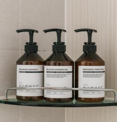 four bottles of soap on a shelf in a bathroom at Stay Hyun in Jeju