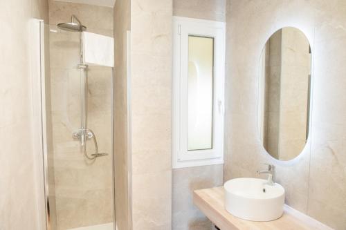 a bathroom with a sink and a shower with a mirror at Apartamentos Suaces in Noja