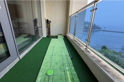 an empty balcony with a green floor and windows at Blanc Hotel & Resort in Yeosu