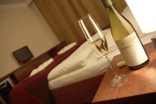 a bottle of wine and a wine glass on a table at Relax Inn in Prague