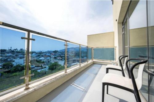 a balcony with chairs and a view of a city at Blanc Hotel & Resort in Yeosu