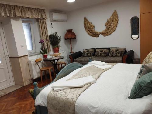 a bedroom with a bed and a living room at Katalin Apartmanok in Hajdúnánás