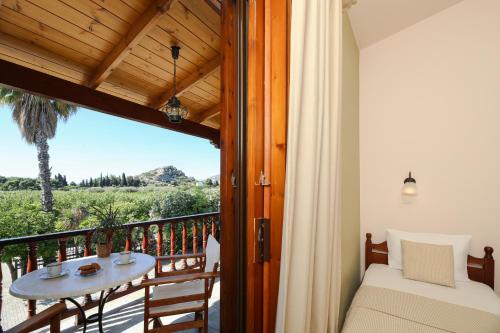 a room with a balcony with a table and a view at Villa Christina in Tolo