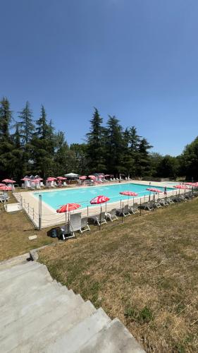 a large swimming pool with chairs and umbrellas at Residenze del Borgo in Zavattarello