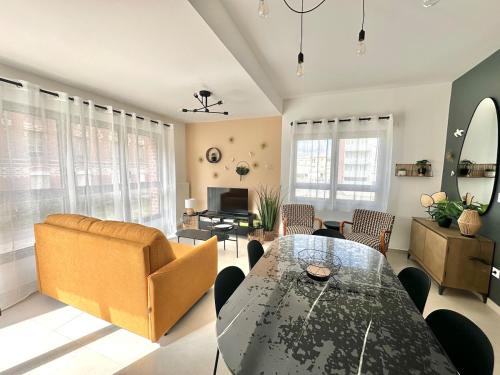a living room with a table and a couch at Charles - Appartement 6 pers avec Parking et Balcon à deux pas de la plage in Berck-sur-Mer