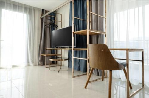 a room with a desk with a television and a chair at Blanc Hotel & Resort in Yeosu