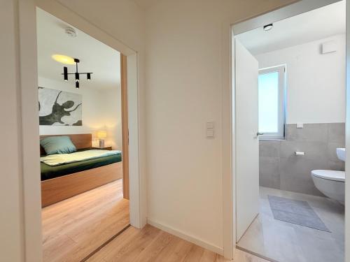 a bathroom with a toilet and a bedroom with a bed at Suite Happiness in Uhldingen-Mühlhofen