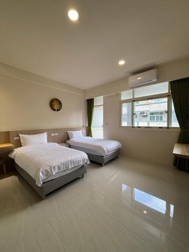 a bedroom with two beds and a window at Qianlian Xiaojing & Xiutian Xiaomind in Longtian