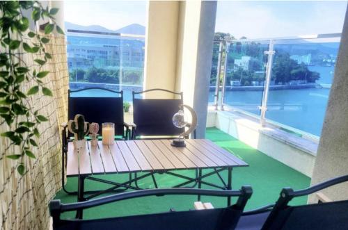 a table on a balcony with a view of the water at Blanc Hotel & Resort in Yeosu