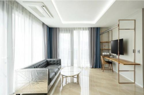a living room with a couch and a table at Blanc Hotel & Resort in Yeosu