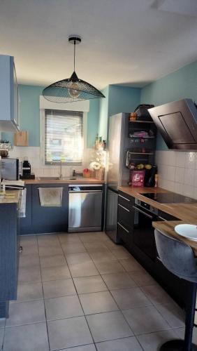 maison proche ocean في سان فينسنت دو تيروسيه: مطبخ به ثلاجة ومغسلة