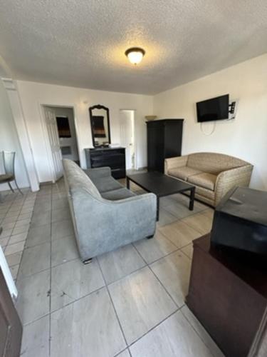 a living room with a couch and a chair at Encore Inn Inglewood in Inglewood