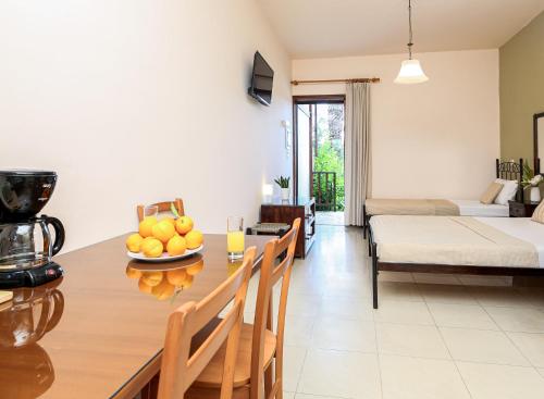 a kitchen and living room with a table with a bowl of fruit at Villa Christina in Tolo