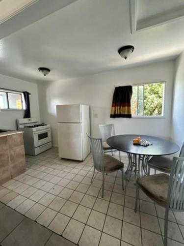 a kitchen with a table and chairs and a refrigerator at Encore Inn Inglewood in Inglewood