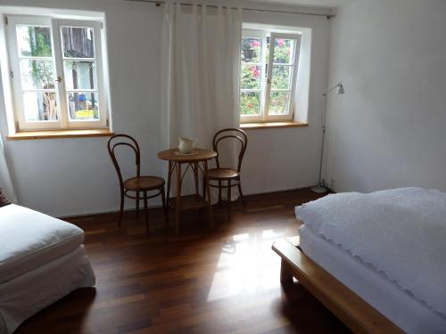 a bedroom with a bed and a table and two chairs at Freiraum Ferienwohnung in Dießen am Ammersee