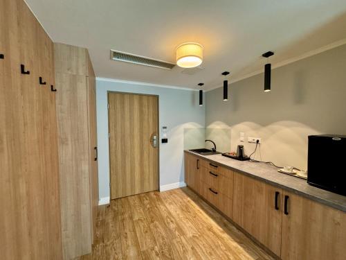 a kitchen with wooden cabinets and a sliding door at Luksusowe Apartamenty Echo in Cedzyna