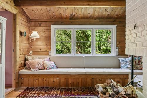 un sofá en una habitación con ventana en Log Cabin Near Vesterstrand On Anholt, en Anholt