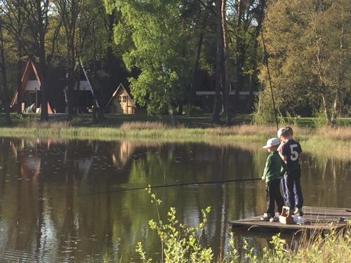two children standing on a raft in a lake at 't Vosseven vakantiehuizen in Stramproy