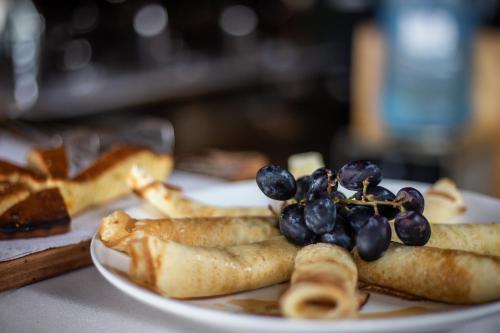 a plate of food with grapes on a table at Eagle View Lodge - Kigali in Kigali