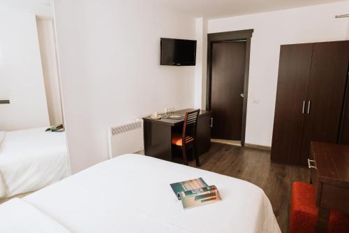 a hotel room with a bed and a desk and a tv at Hotel Duke Armeneasca City Center in Bucharest