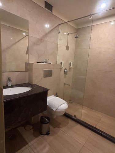 a bathroom with a sink and a toilet and a shower at Mj Aero Suite in Dehradun Airport