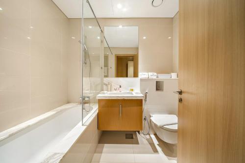 a bathroom with a sink and a toilet and a shower at FIRST CLASS 2BR Timeless Vibes & Pool View in Dubai