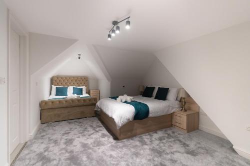 a bedroom with two beds in a attic at D'Luxe 3 - 5 beds En-suite Home in London in Isleworth