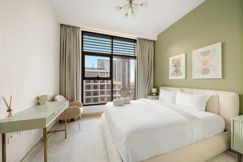 a bedroom with a bed and a desk and a window at FIRST CLASS 2BR Timeless Vibes & Pool View in Dubai