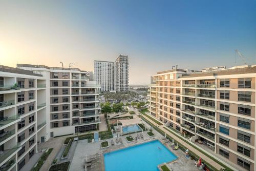 an aerial view of buildings and a swimming pool at FIRST CLASS 2BR Timeless Vibes & Pool View in Dubai