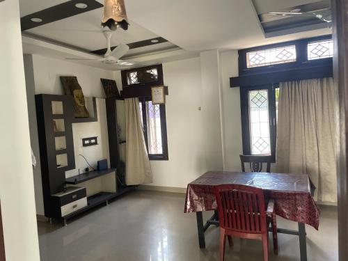 グワーハーティーにあるAatithya Home Stayのテーブルと椅子2脚のあるダイニングルーム