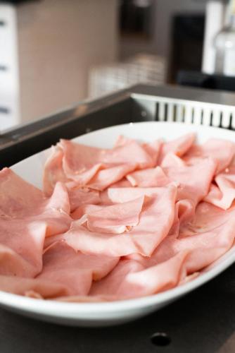 a plate of ham sitting on a table at Hotel De Nac in Nago-Torbole