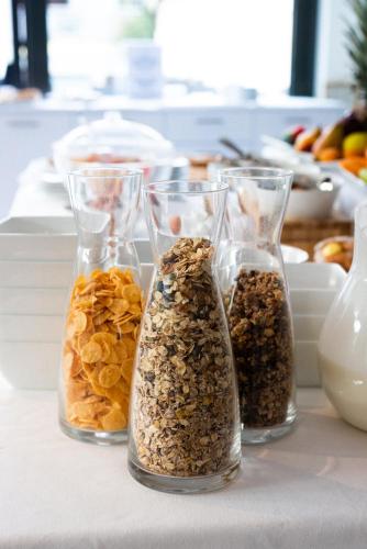 four glass vases filled with different types of seeds at Hotel De Nac in Nago-Torbole