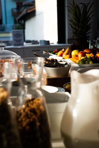 a buffet line with plates of food and fruits at Hotel De Nac in Nago-Torbole