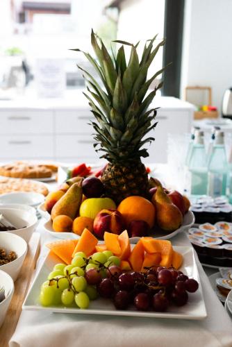 a tray of fruit on a table with a pineapple at Hotel De Nac in Nago-Torbole