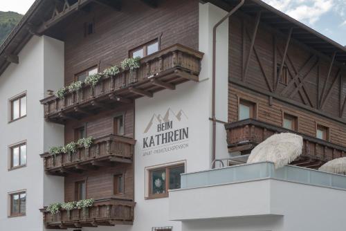 a building with wooden balconies and a sign that reads ben kurion at Beim Kathrein - inklusive SILVRETTA Card Premium in Galtür