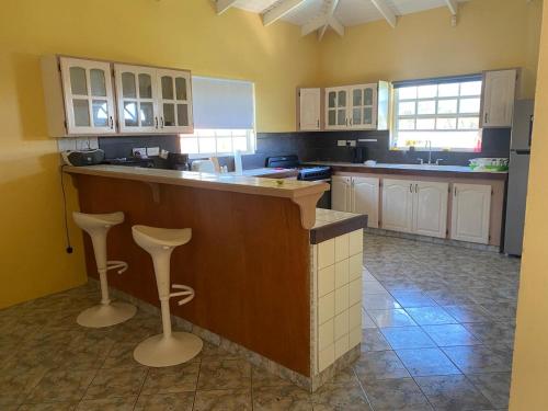 a kitchen with a counter and two bar stools at Cummin up in Fort Jeudy