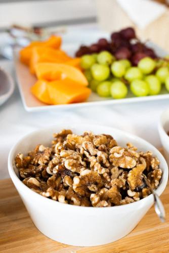a bowl of granola on a table with a plate of fruit at Hotel De Nac in Nago-Torbole